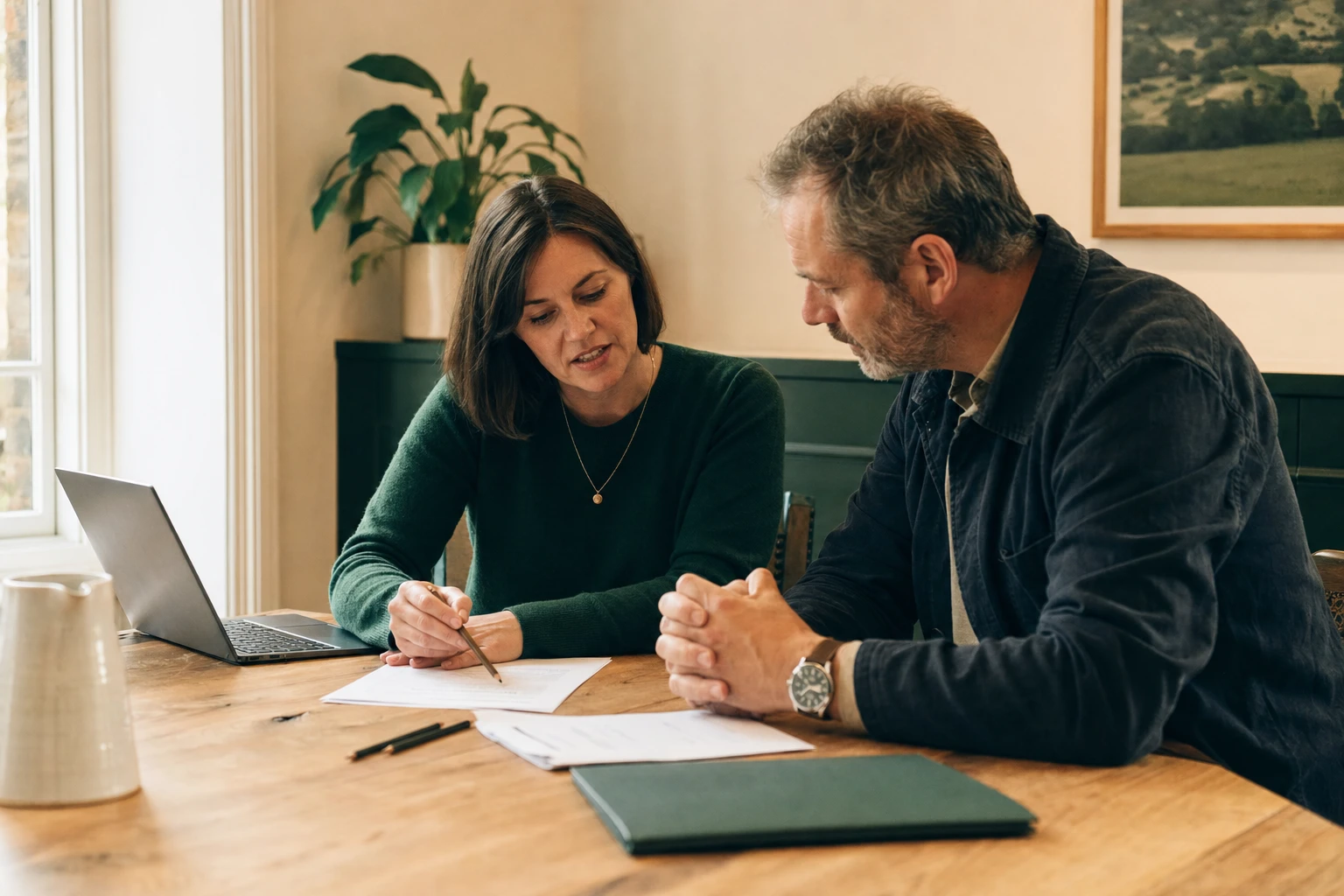 Illustrative scene of a consultant and client reviewing project documents together in a sunlit meeting room.