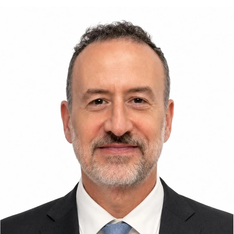 Front-facing studio portrait of Baran in a dark suit against a white background